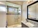 Modern bathroom with granite countertops, framed mirror, and glass enclosed shower, offering luxurious space at 11511 Harbourside Ln, Parrish, FL 34219