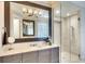 Modern bathroom featuring a gray vanity, granite countertop, large mirror, and a glass enclosed shower at 11511 Harbourside Ln, Parrish, FL 34219