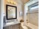 Well-lit bathroom showcasing a granite countertop vanity, a framed mirror, and a shower-tub combination at 11511 Harbourside Ln, Parrish, FL 34219