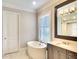 Elegant bathroom features a soaking tub, dual vanity, and a walk-in shower at 11511 Harbourside Ln, Parrish, FL 34219