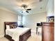 Bedroom with a dark wood bed frame, neutral walls, and a ceiling fan providing a relaxing atmosphere at 11511 Harbourside Ln, Parrish, FL 34219