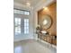 Elegant entryway featuring double doors, console table, decorative mirror, and neutral color palette at 11511 Harbourside Ln, Parrish, FL 34219