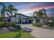 Beautiful Mediterranean-style home with a brick driveway, two-car garage, and palm tree landscaping at 11511 Harbourside Ln, Parrish, FL 34219