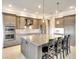 Bright kitchen features stainless steel appliances, granite countertops, oversized island with bar seating, and stylish pendant lights at 11511 Harbourside Ln, Parrish, FL 34219