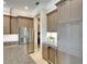 Bright and airy kitchen features stainless steel refrigerator and wine cooler, as well as custom cabinets at 11511 Harbourside Ln, Parrish, FL 34219