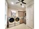 Functional laundry room with modern washer and dryer, featuring ample cabinet space and neutral decor at 11511 Harbourside Ln, Parrish, FL 34219