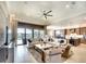 Spacious living room featuring a large sectional sofa, tray ceiling, and sliding glass doors to the outdoor area at 11511 Harbourside Ln, Parrish, FL 34219