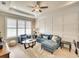 Charming living room with a tray ceiling, decorative wall trim, and comfortable blue furniture at 11511 Harbourside Ln, Parrish, FL 34219