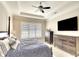 Well-lit main bedroom features a tray ceiling, plantation shutters, and stylish furniture at 11511 Harbourside Ln, Parrish, FL 34219