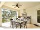 Covered outdoor kitchen featuring stainless steel appliances, a grill, and a dining area, perfect for entertaining at 11511 Harbourside Ln, Parrish, FL 34219