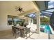 Spacious covered patio features a dining set, screened-in pool, and outdoor living space, perfect for entertaining at 11511 Harbourside Ln, Parrish, FL 34219