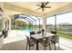 Covered patio with a dining set overlooking a screened-in pool, and scenic waterfront view at 11511 Harbourside Ln, Parrish, FL 34219