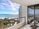 A covered balcony with seating, offering a scenic view of the ocean and nearby greenery at 1211 Gulf Of Mexico Dr # 702, Longboat Key, FL 34228