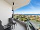 Relaxing balcony with seating overlooking lush landscaping, tennis courts, and stunning ocean vistas at 1211 Gulf Of Mexico Dr # 702, Longboat Key, FL 34228