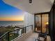 Balcony with a glass railing offering breathtaking ocean views at sunset with outdoor seating for relaxation at 1211 Gulf Of Mexico Dr # 702, Longboat Key, FL 34228