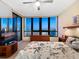 Bright bedroom with floor-to-ceiling windows offering an ocean view, a ceiling fan, and comfortable furnishings at 1211 Gulf Of Mexico Dr # 702, Longboat Key, FL 34228