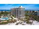 A luxury condo building boasts a beachside pool, lush landscaping, and ocean views at 1211 Gulf Of Mexico Dr # 702, Longboat Key, FL 34228