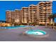 Luxury beachfront condominium featuring a pool, hot tub, lush landscaping, and stunning architectural design at 1211 Gulf Of Mexico Dr # 702, Longboat Key, FL 34228