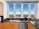 Modern kitchen showcasing granite countertops, a stainless steel dishwasher, sink, and windows with lovely water views at 1211 Gulf Of Mexico Dr # 702, Longboat Key, FL 34228
