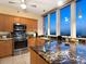 Well-equipped kitchen with granite countertops, stainless steel appliances, and panoramic views from large windows at 1211 Gulf Of Mexico Dr # 702, Longboat Key, FL 34228