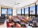 Bright living room featuring a large leather couch, modern rug, and floor-to-ceiling windows showcasing stunning waterfront views at 1211 Gulf Of Mexico Dr # 702, Longboat Key, FL 34228