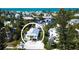 Aerial view shows a coastal neighborhood with mature trees and a home near the water at 123 Hammock Rd, Anna Maria, FL 34216