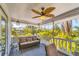 Relaxing screened-in porch with comfortable seating, a ceiling fan, and views of the lush tropical surroundings at 123 Hammock Rd, Anna Maria, FL 34216