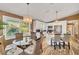 Charming dining area with a chandelier, glass table, and wicker chairs, next to an open-concept kitchen at 123 Hammock Rd, Anna Maria, FL 34216