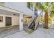 Exterior view of the house with stairs leading to the entrance, and a well-maintained yard with a palm tree at 123 Hammock Rd, Anna Maria, FL 34216