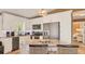 Modern kitchen with an island, stainless steel appliances, and wood look floors at 123 Hammock Rd, Anna Maria, FL 34216