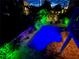 Backyard pool area featuring ambient lighting, creating a tranquil nighttime retreat at 123 Hammock Rd, Anna Maria, FL 34216