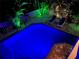 Inviting pool area illuminated with vibrant lighting, creating a relaxing backyard oasis at 123 Hammock Rd, Anna Maria, FL 34216