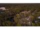 Aerial view showcasing the house near a pond with a white fence visible in the surrounding woods at 13608 11Th E Ter, Bradenton, FL 34212