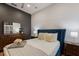 Bedroom featuring a navy blue headboard, white duvet, and stylish wood dresser at 13608 11Th E Ter, Bradenton, FL 34212