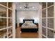 Bedroom with a navy blue headboard, white duvet, ceiling fan, and french doors at 13608 11Th E Ter, Bradenton, FL 34212