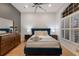 Bedroom with a navy blue headboard, white duvet, and plantation shutters at 13608 11Th E Ter, Bradenton, FL 34212
