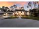 Lovely home with a curved drive, well-manicured landscaping, and a three-car garage during sunset at 13608 11Th E Ter, Bradenton, FL 34212
