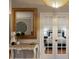 Elegant hallway with ornate table and mirror leading to a bedroom with french doors at 13608 11Th E Ter, Bradenton, FL 34212