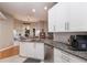 Modern kitchen featuring granite countertops and white cabinetry with a view to the dining area at 13608 11Th E Ter, Bradenton, FL 34212