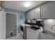 Laundry room with gray cabinets, shelf, and front load washer and dryer at 13608 11Th E Ter, Bradenton, FL 34212