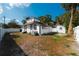 Back exterior view of white home with black trim and a spacious fenced-in yard at 1397 43Rd St, Sarasota, FL 34234