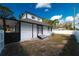 Rear exterior of home with a white fence, and mature trees at 1397 43Rd St, Sarasota, FL 34234