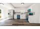 Modern kitchen featuring stainless steel appliances, bright white cabinetry, marble countertops, and sleek, wood-style flooring at 1397 43Rd St, Sarasota, FL 34234