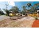 Neighborhood view showcasing a charming yellow home and vibrant greenery, enhancing the appeal of the surrounding community at 1397 43Rd St, Sarasota, FL 34234