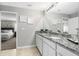 Bathroom featuring a granite countertop, double sinks, and an open view into an adjacent bedroom at 15110 Keene Ave, Port Charlotte, FL 33953