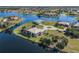 Expansive aerial shot of a waterfront home featuring mature landscaping, circular driveway, and serene water views at 16211 Cayman Ln, Punta Gorda, FL 33955