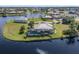 Stunning aerial view of a waterfront property with a screened pool and lush landscaping in a serene neighborhood at 16211 Cayman Ln, Punta Gorda, FL 33955