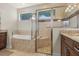 This primary bathroom features a soaking tub, a glass-enclosed shower, and granite countertops at 16211 Cayman Ln, Punta Gorda, FL 33955