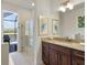 This bathroom features wood cabinetry, granite countertops, and a frameless glass shower at 16211 Cayman Ln, Punta Gorda, FL 33955