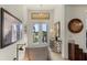Inviting foyer with a stylish console table, artwork, and a view of the outdoors through glass doors at 16211 Cayman Ln, Punta Gorda, FL 33955